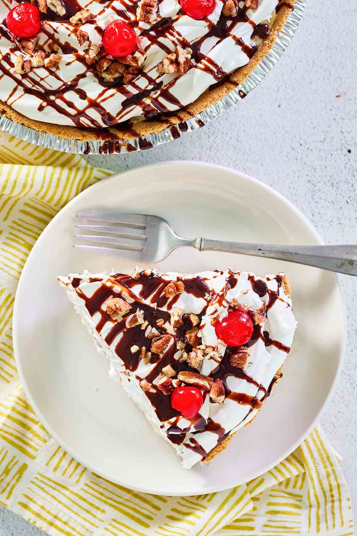 overhead view of banana split pie slice on a plate next to the pie.