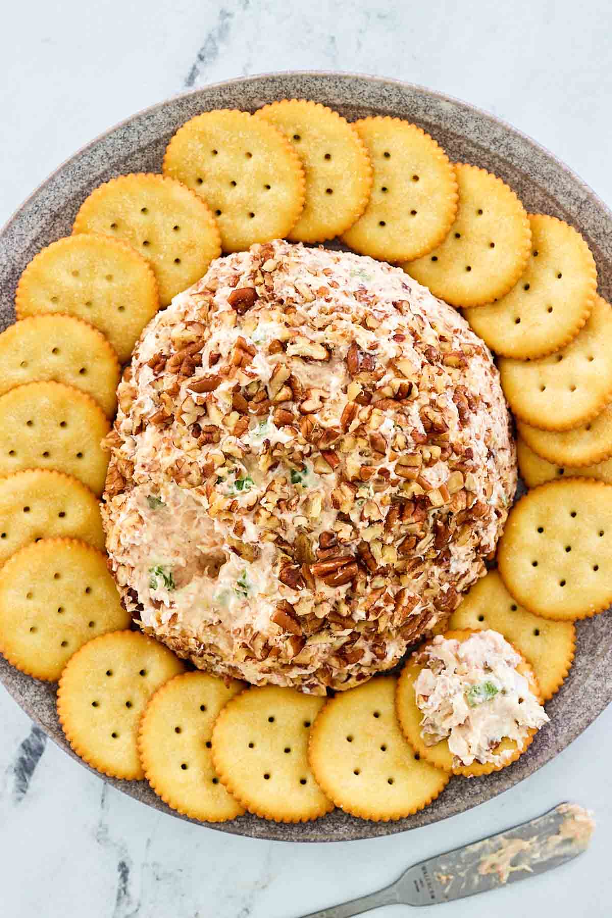 overhead view of deviled ham cheese ball on a platter with crackers.