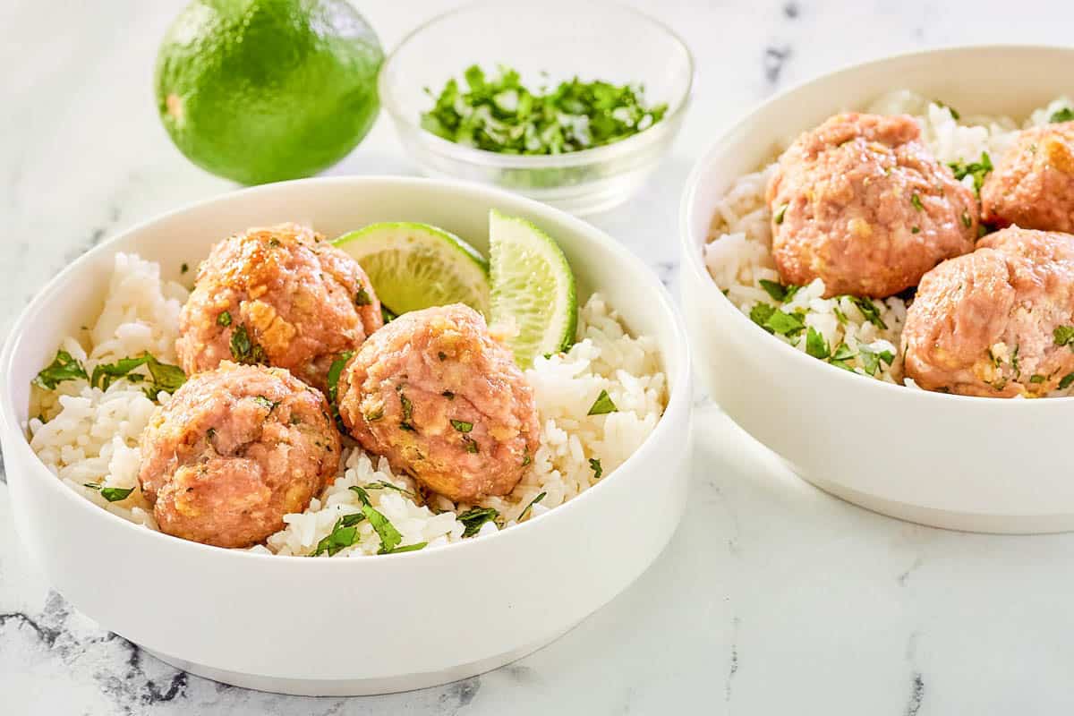 Asian pork meatballs and rice in two bowls.
