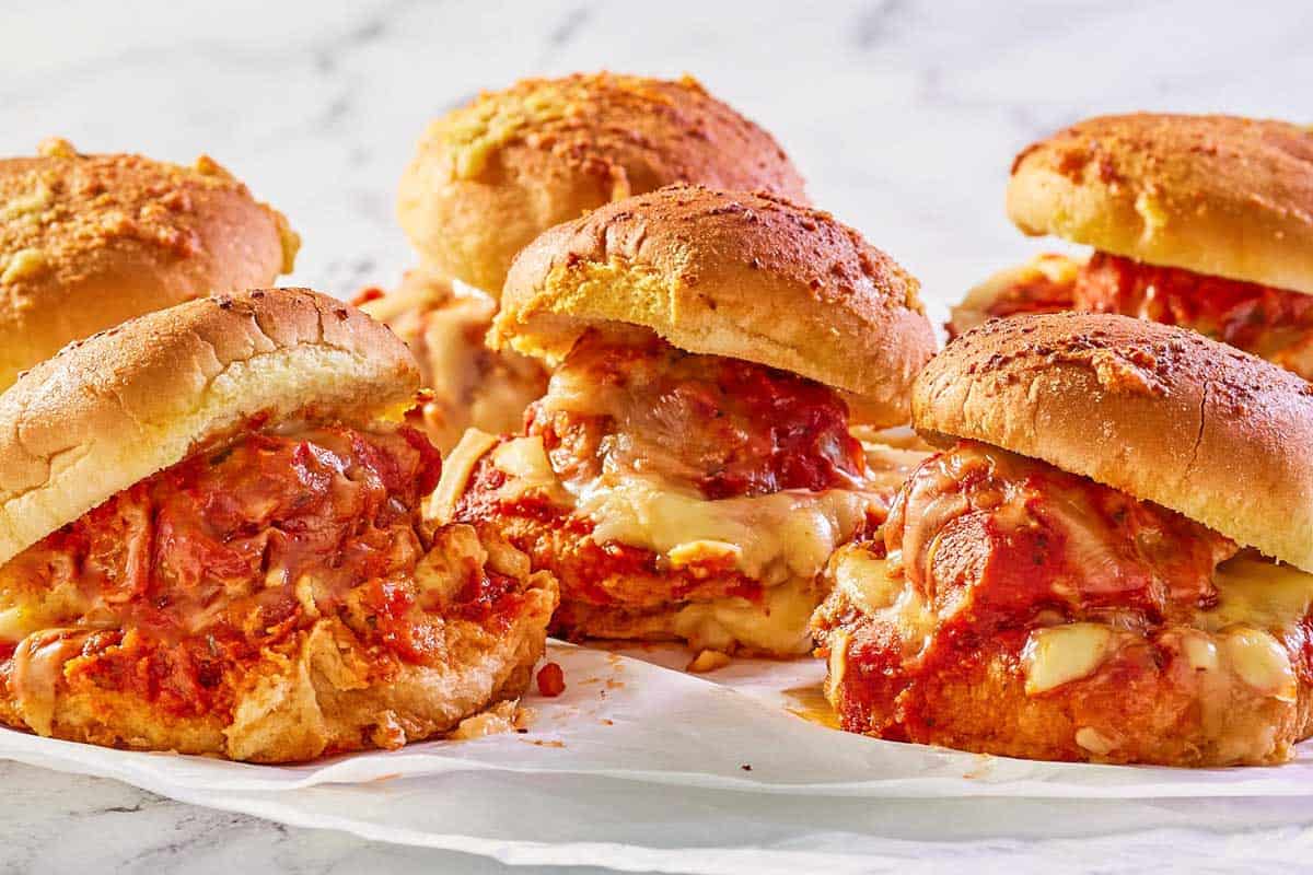 six meatball sliders on parchment paper.