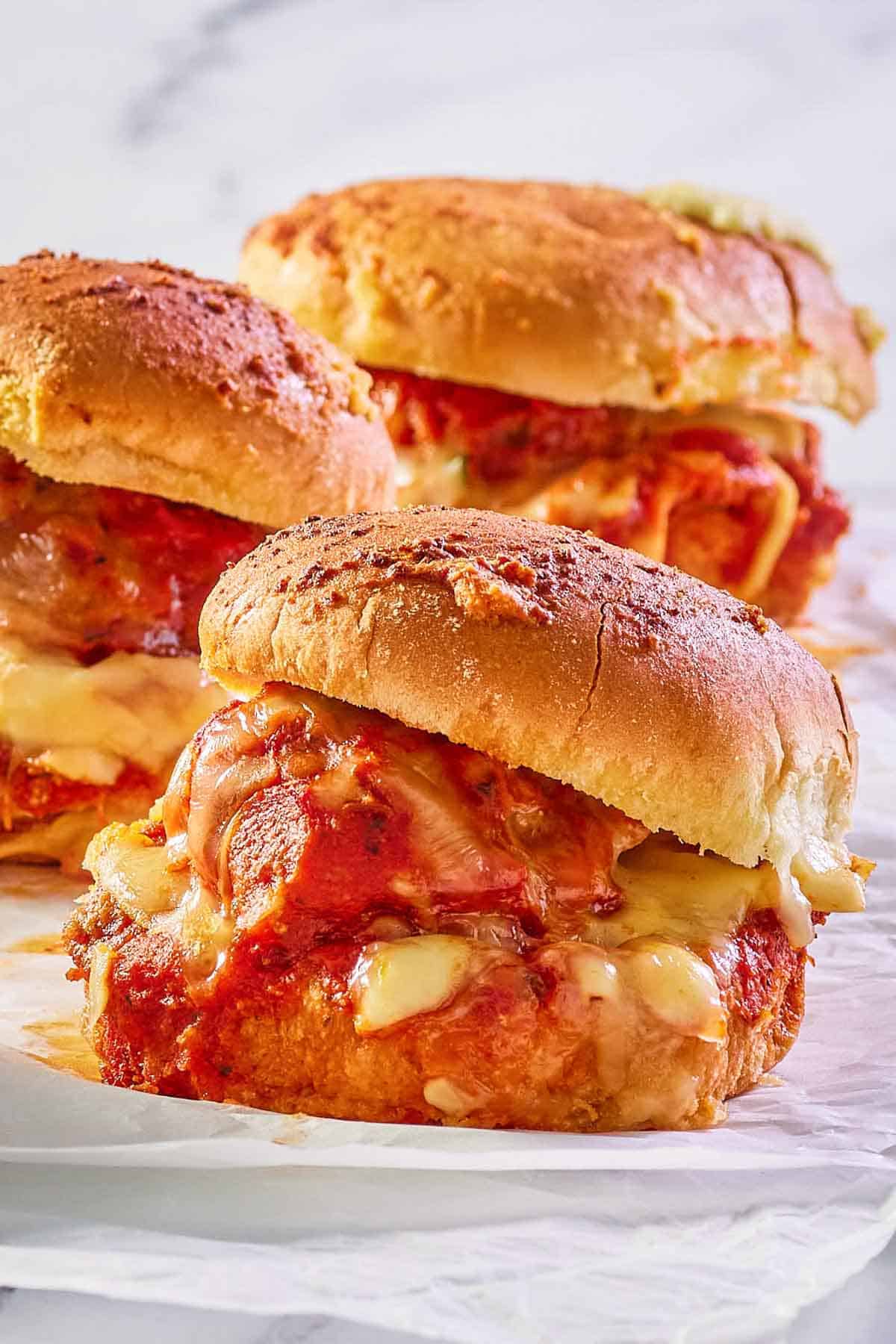 three meatball sliders on parchment paper.
