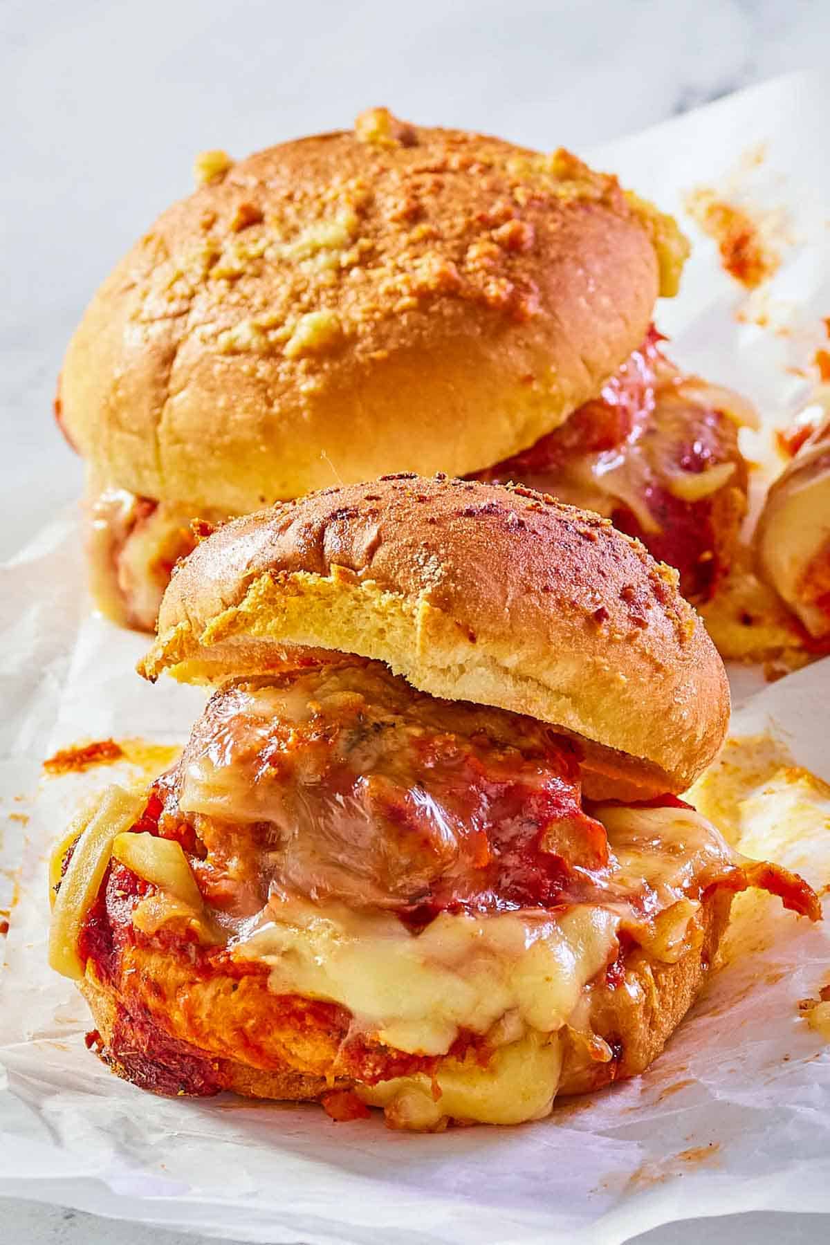 two meatball sliders on parchment paper.