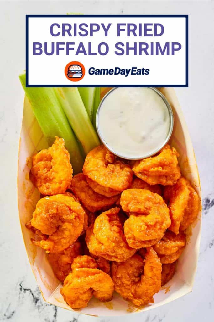 overhead view of buffalo shrimp, celery, and blue cheese dressing in a paper basket.