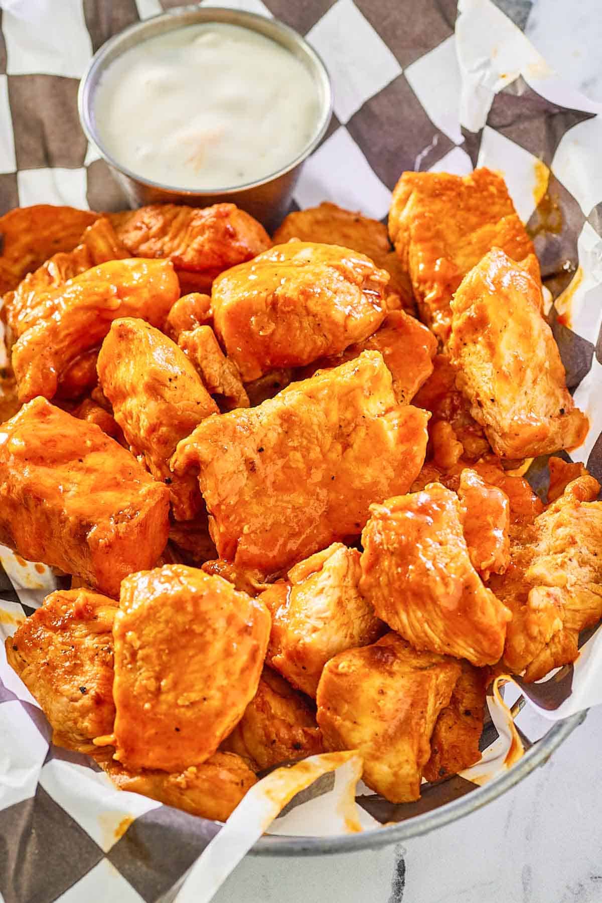 a basket of grilled buffalo chicken bites with blue cheese dressing.