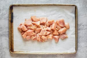 raw chicken pieces on a tray.