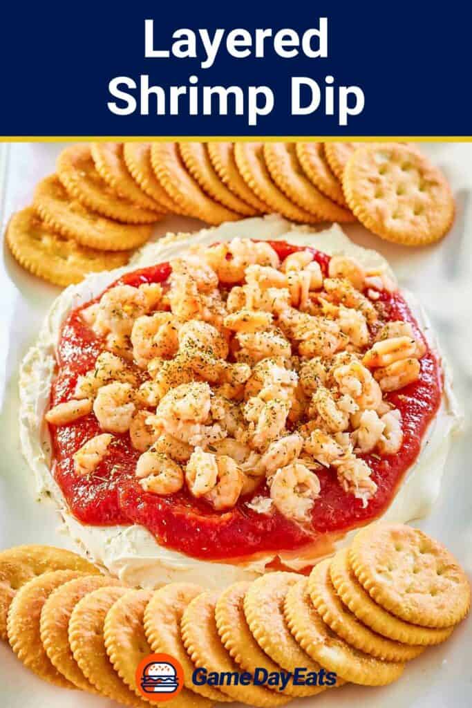 layered shrimp dip and round crackers on a platter.