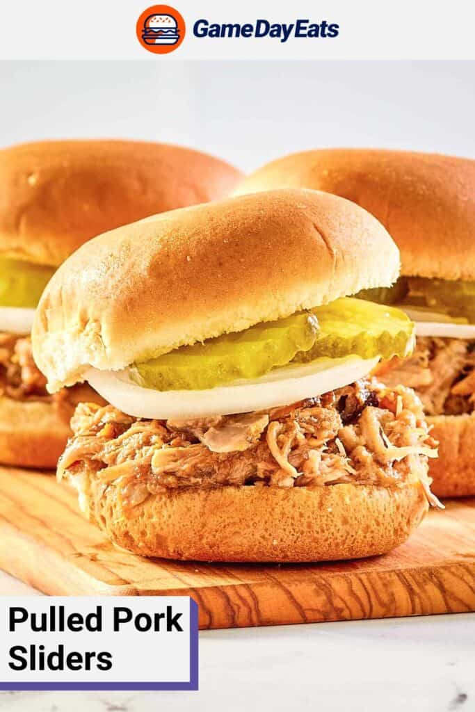 pulled pork sliders with onion and pickles on a board.