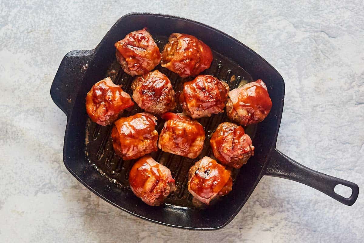 smoked meatballs coated with barbecue sauce in a pan.