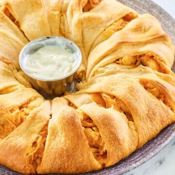 Buffalo chicken crescent ring and a small cup of ranch dressing in the center of it.