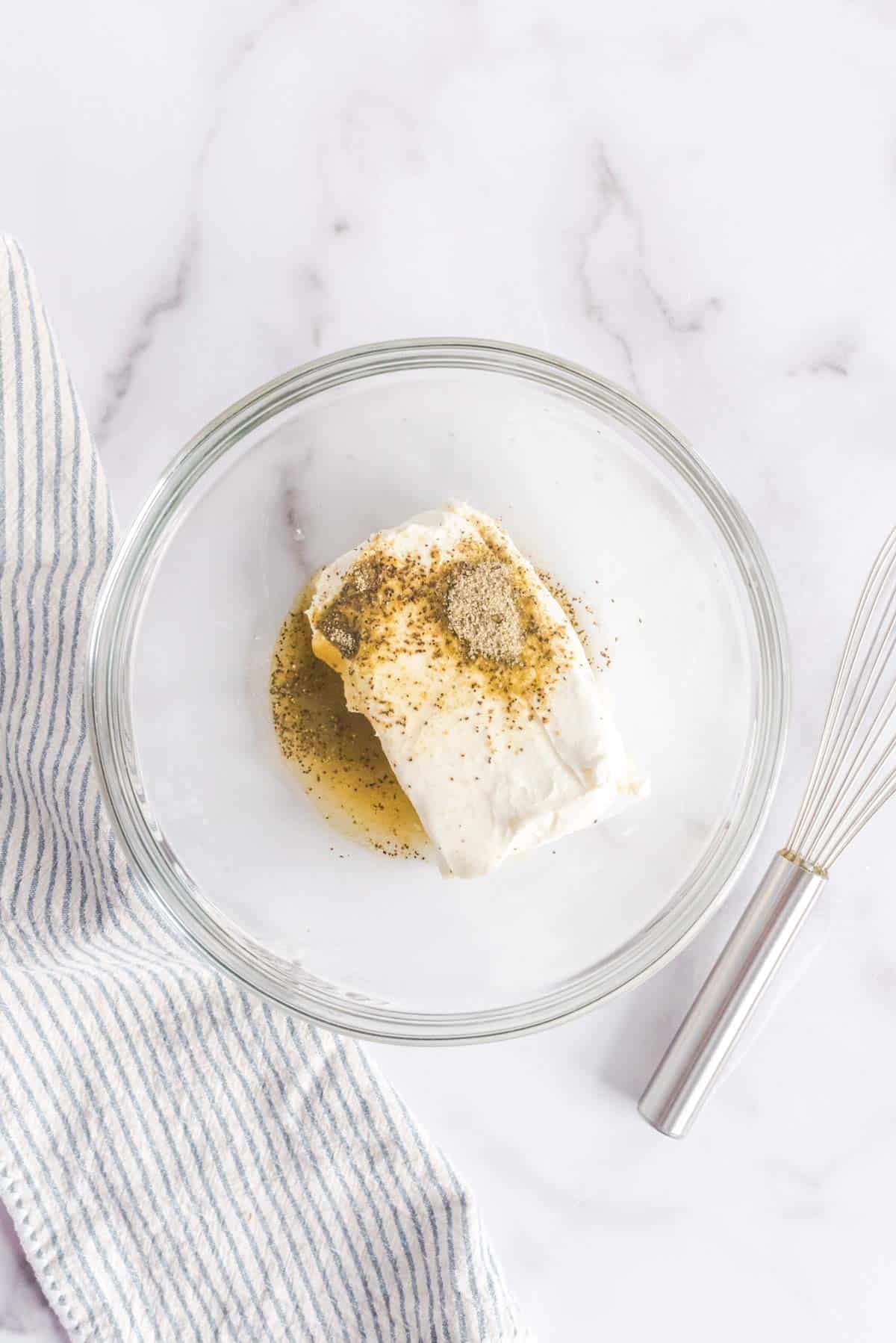 Cream cheese, garlic, lemon, and Greek seasoning in a bowl.