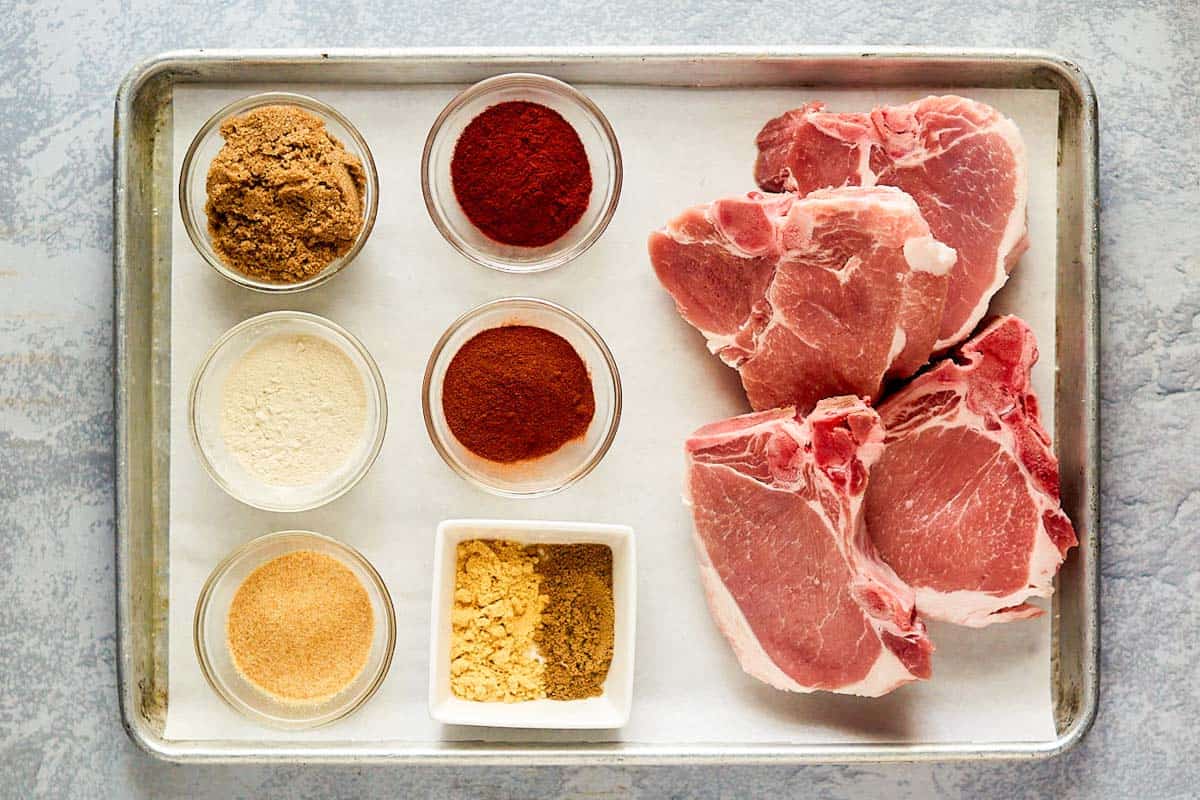 Air fryer thick pork chops ingredients on a tray.