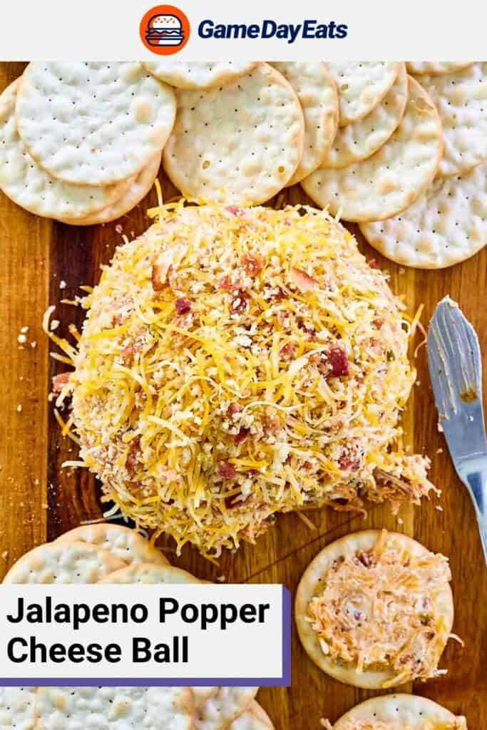 Overhead view of jalapeno popper cheese ball and crackers on a wood board.