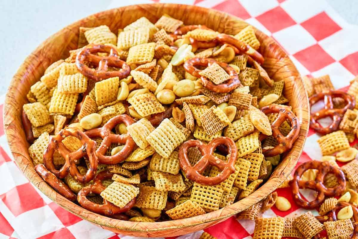 Homemade smoked chex mix in a bowl and some beside it.