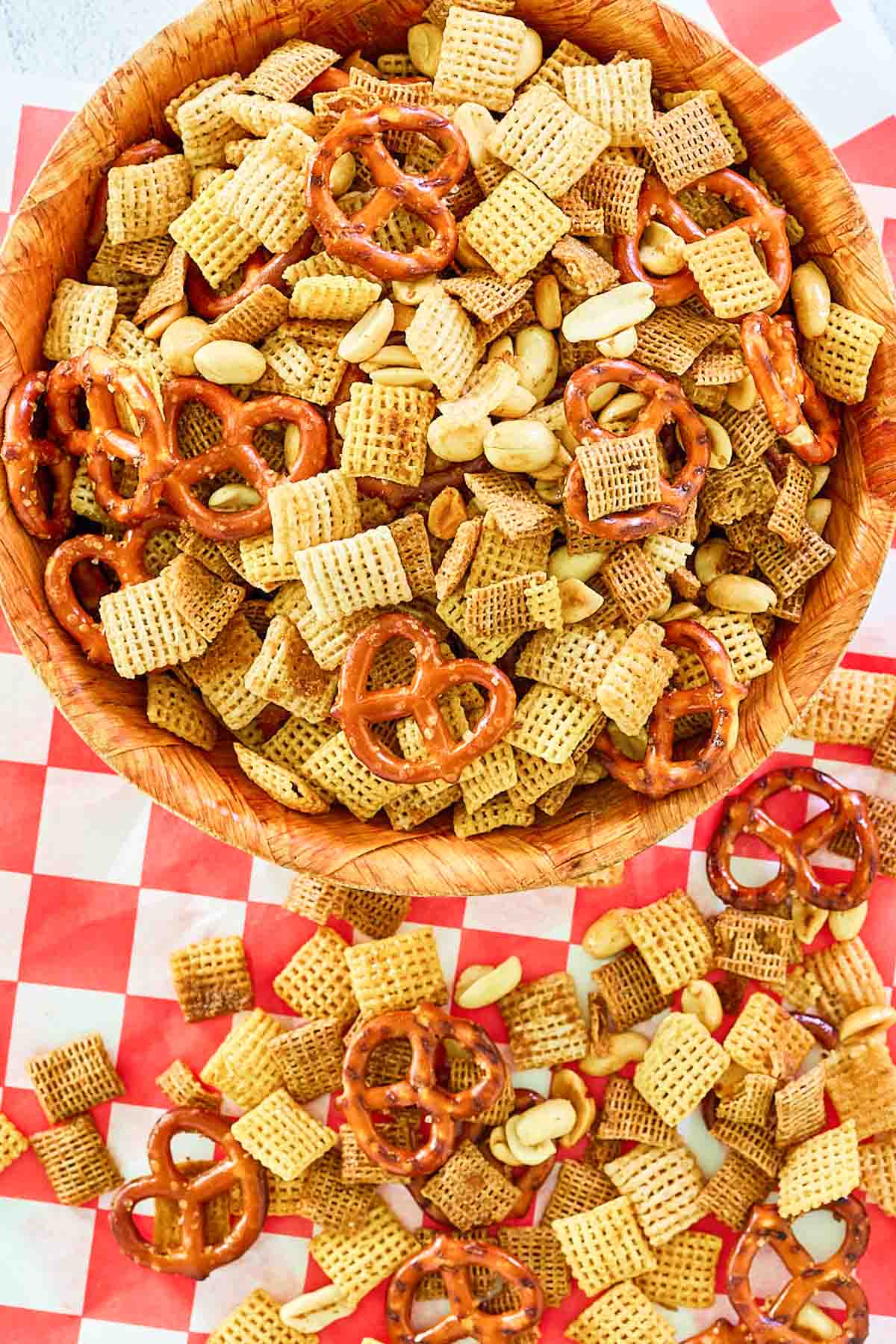 Overhead view of smoked chex mix in a bowl and on parchment paper.