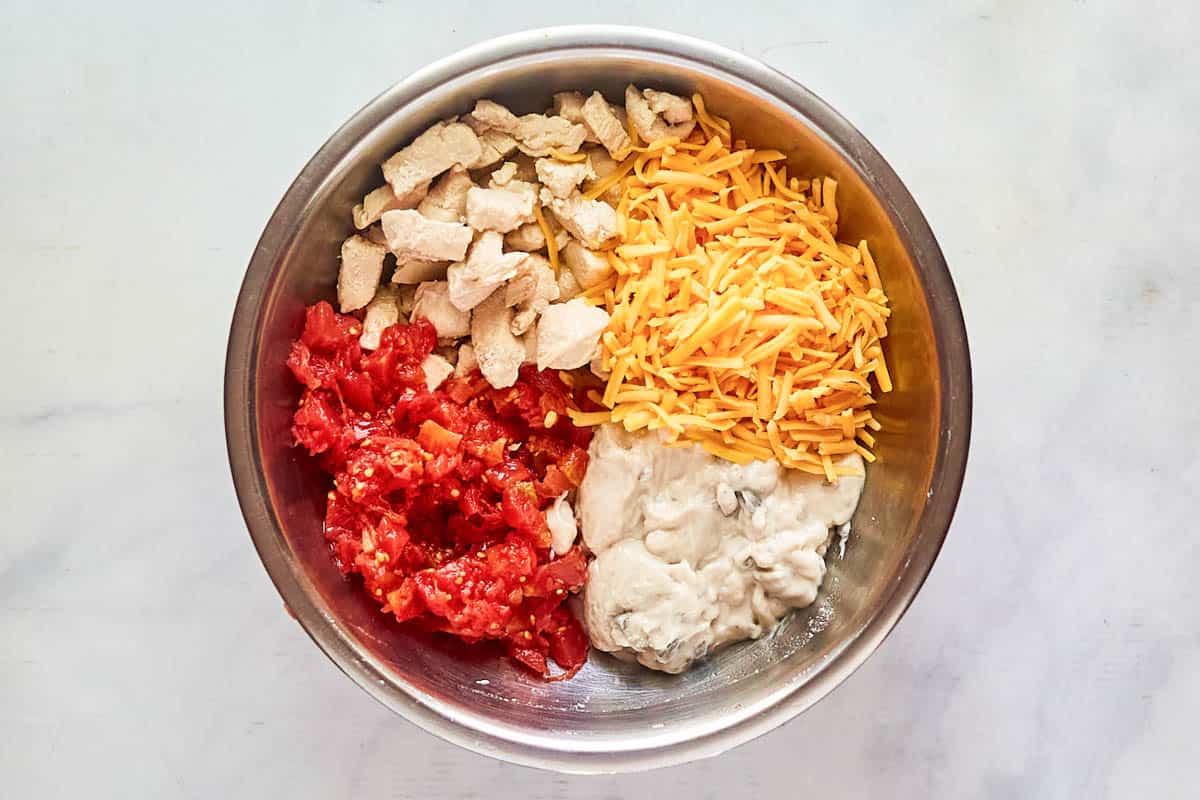 Chicken rotel dip ingredients in a mixing bowl.