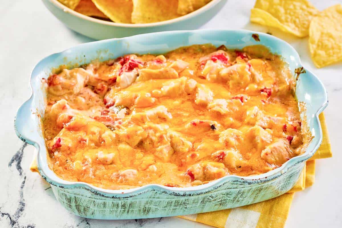 Chicken rotel dip in a baking dish and tortilla chips next to it.