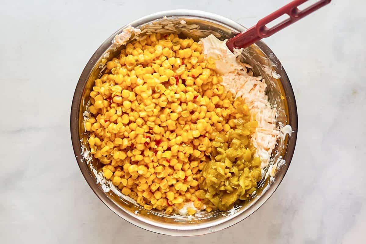 Adding corn kernels to dip mixture.
