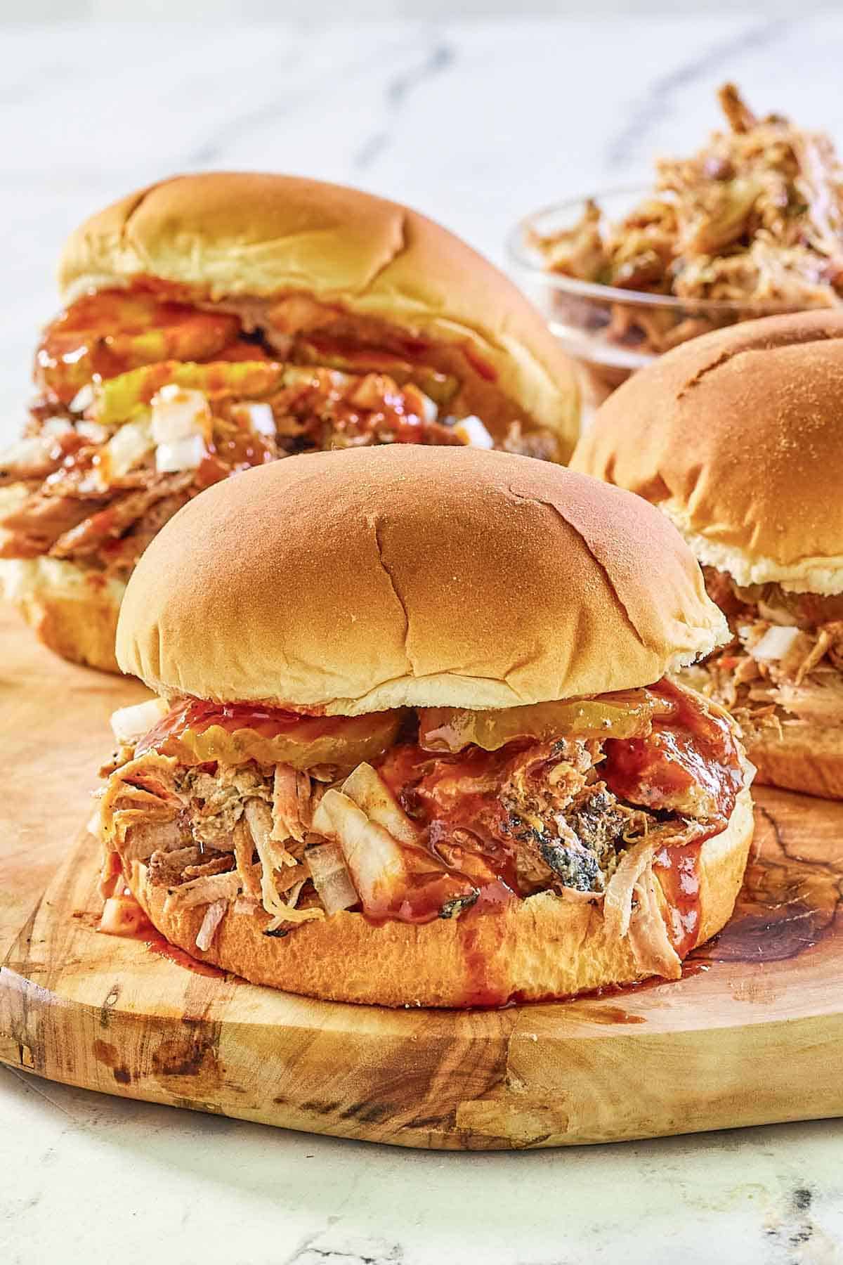 Smoked pulled pork sandwiches on a wood board.
