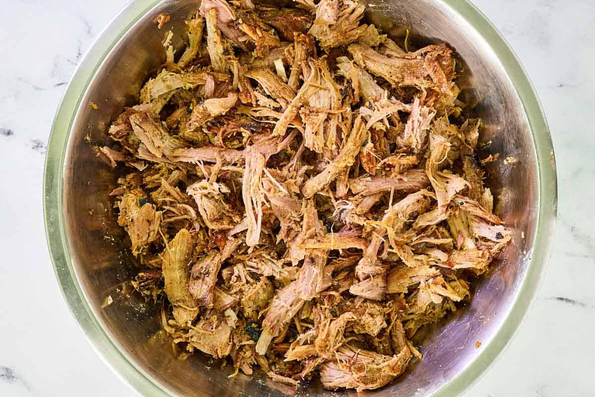 Smoked pulled pork in a metal bowl.