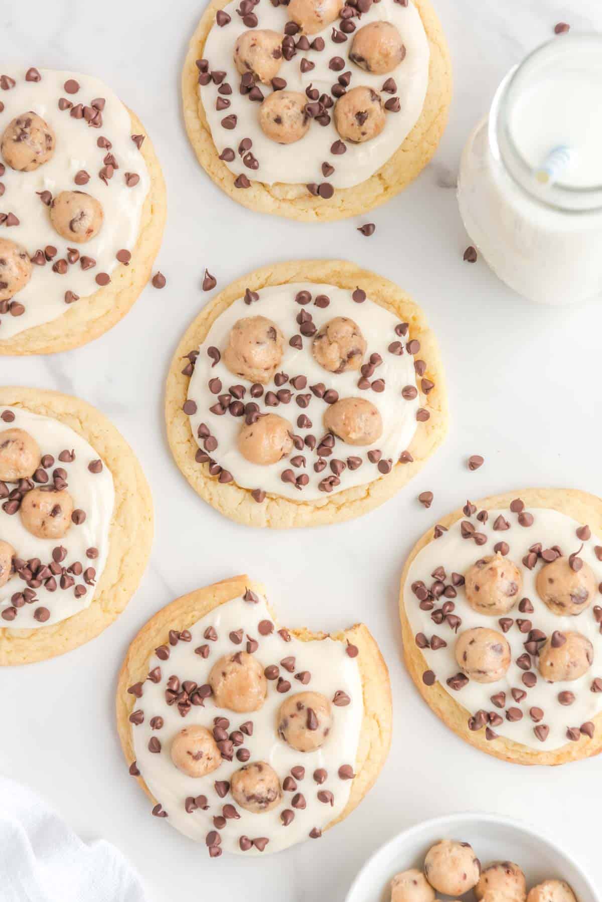 Overhead view of frosted cookie dough cookies on a marble surface.