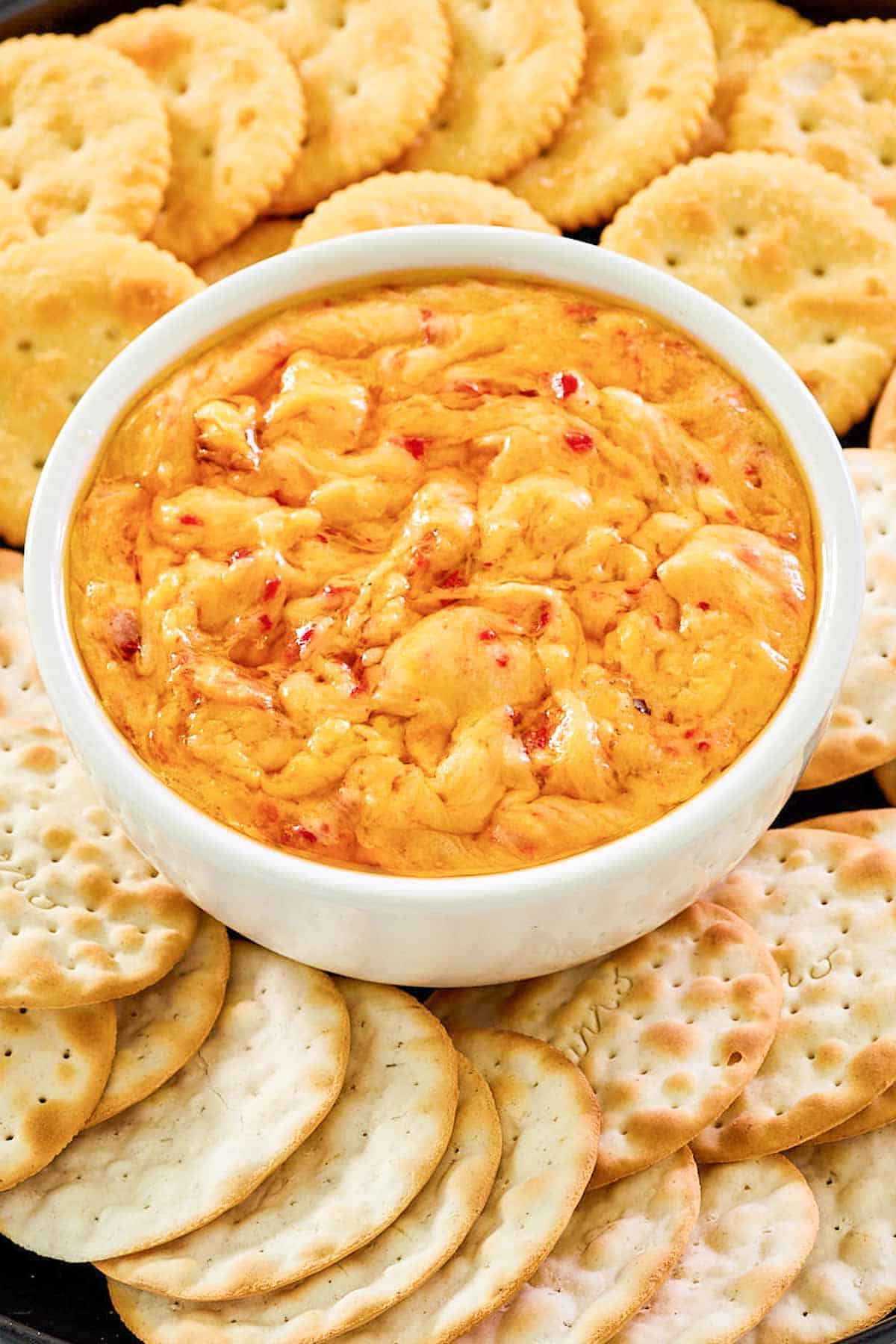 Hot pimento cheese dip and crackers on a platter.