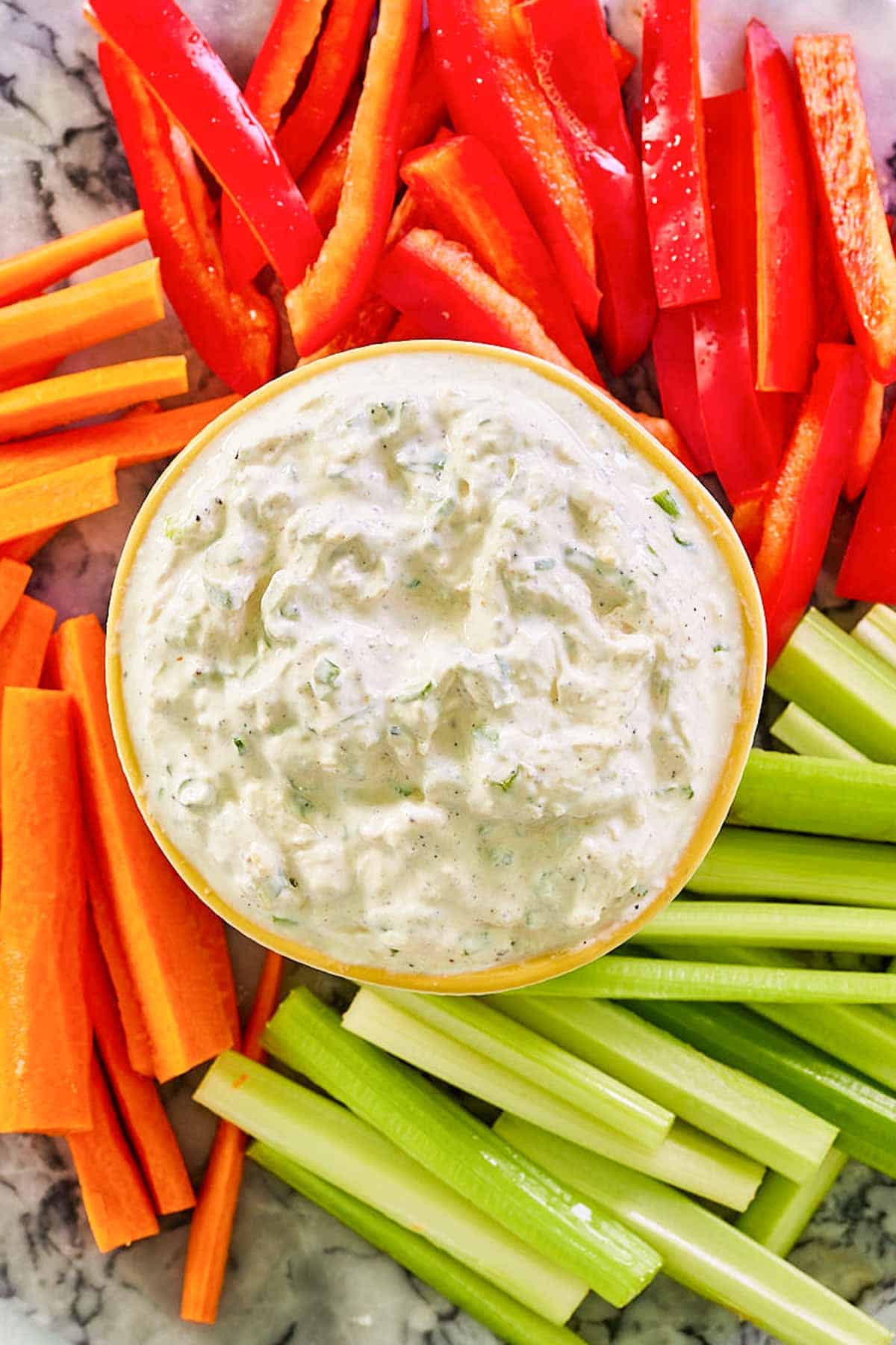 Overhead view of homemade green onion dip and fresh veggies on a platter.