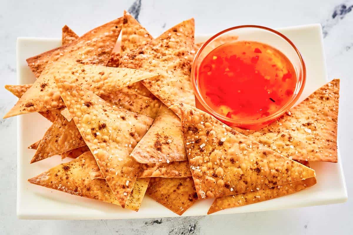 A platter with air fryer wonton chips and dipping sauce.