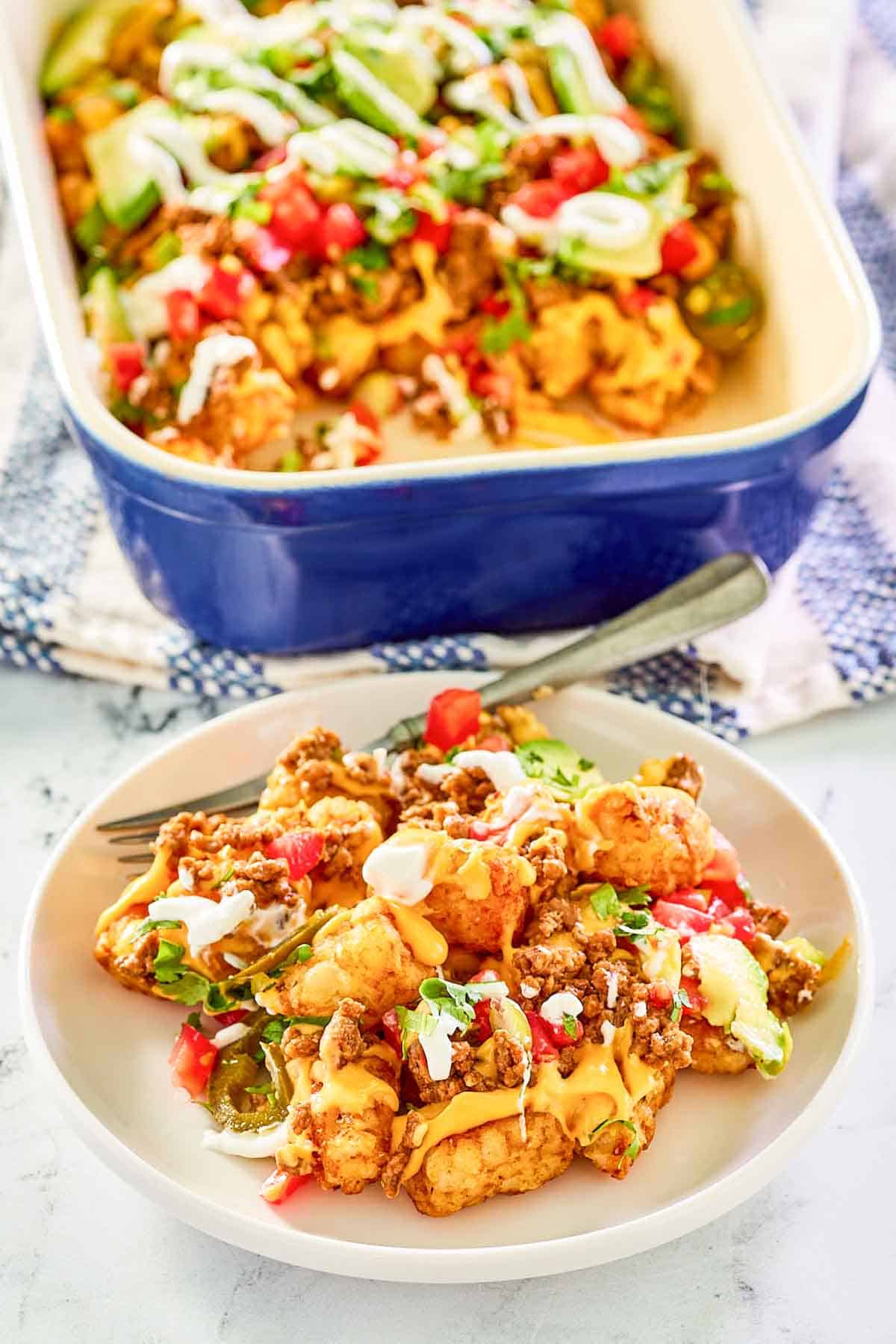 Ground beef totchos in a baking dish and a serving on a plate.