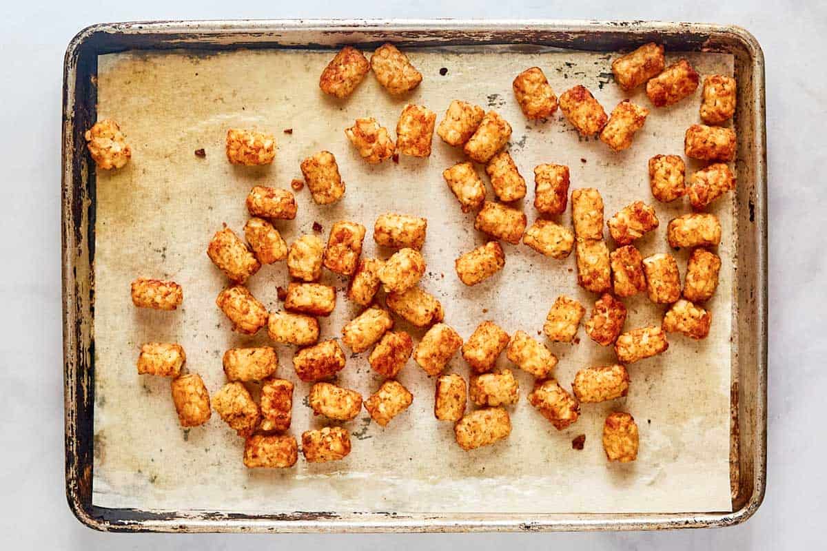 Baked tater tots on a baking sheet.