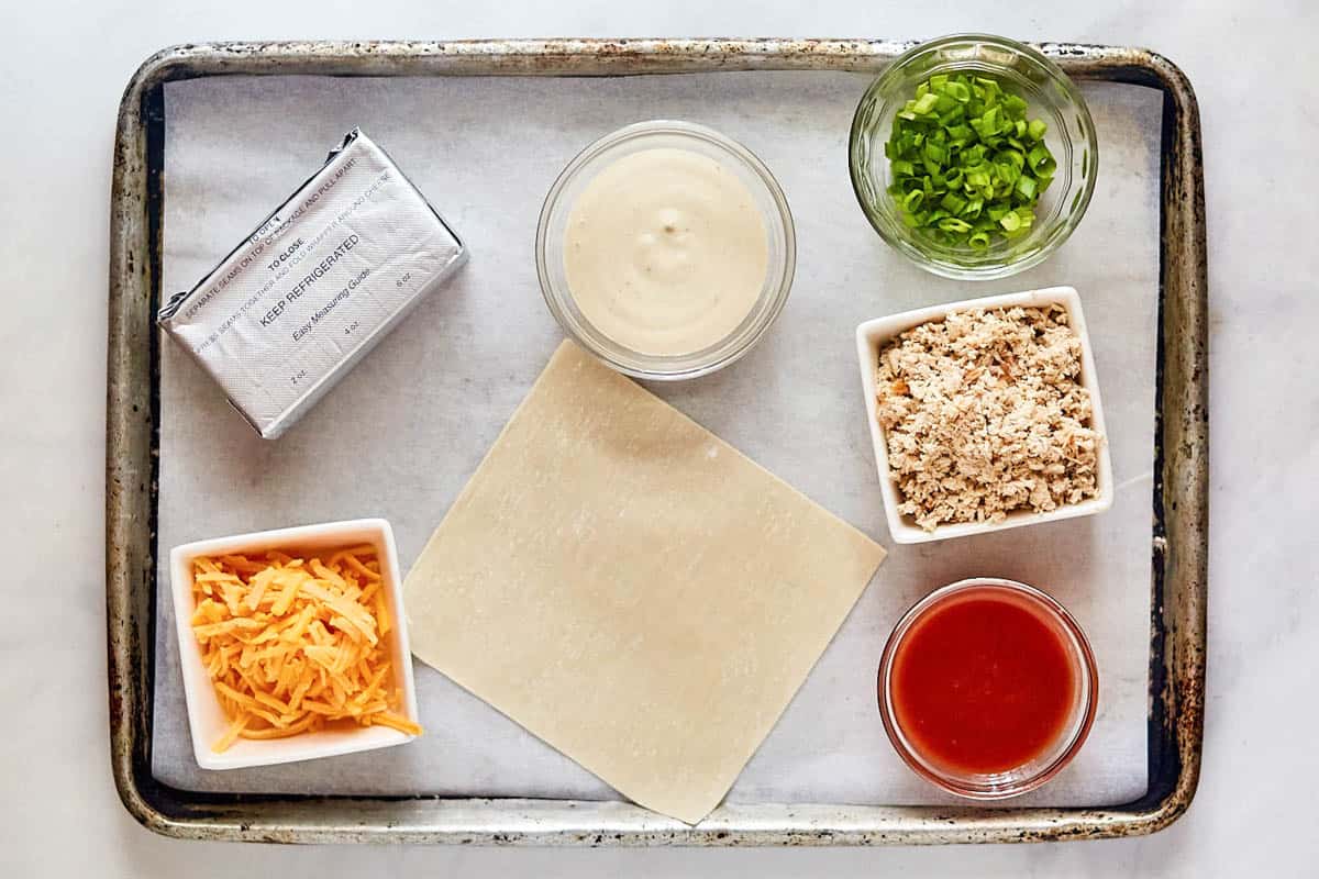 Buffalo chicken egg rolls ingredients on a tray.