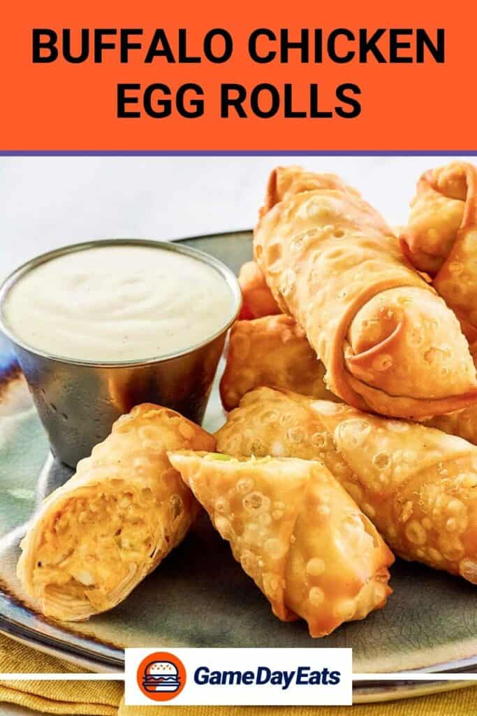 Buffalo chicken egg rolls piled on a plate and a cup of dipping sauce next to them.