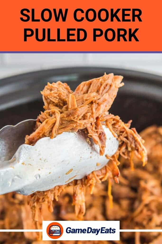Kitchen tongs holding slow cooker pulled pork over a Crockpot.