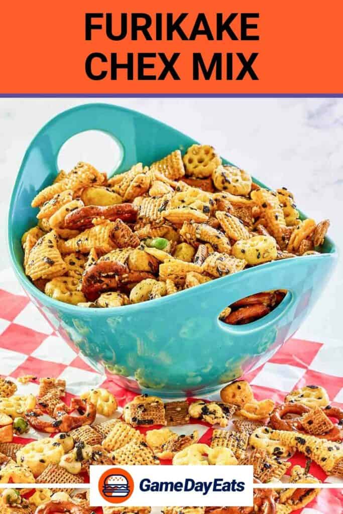 Homemade Furikake Chex Mix in a blue bowl and scattered in front of it on parchment paper.