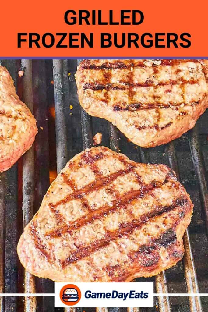 Grilled frozen burger patties on grill grates.