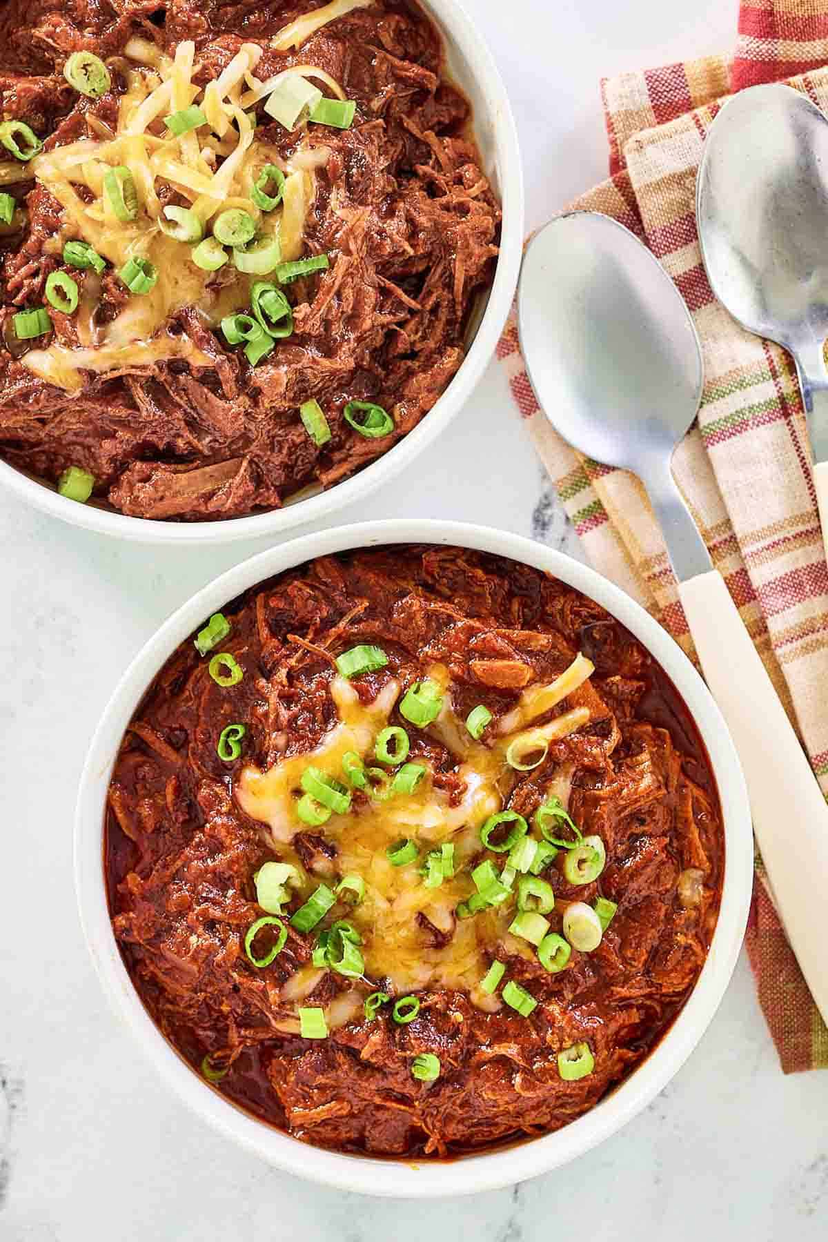 Brisket chili topped with cheese and green onions.