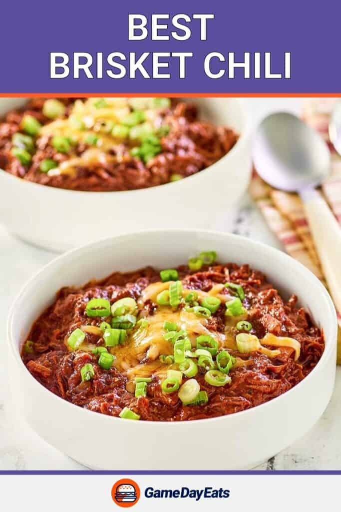 Two bowls of brisket chili topped with cheese and green onions.