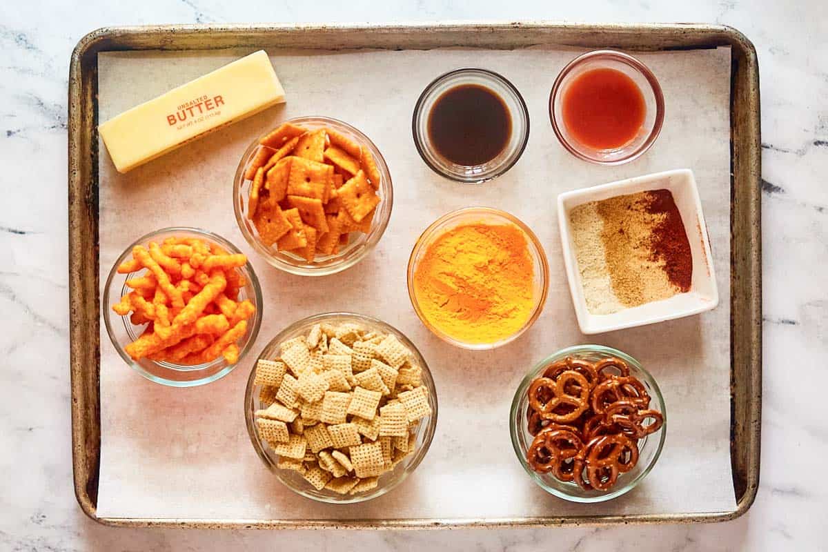 Homemade cheddar Chex mix ingredients on a tray.