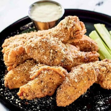 Breaded garlic parmesan wings on a plate.