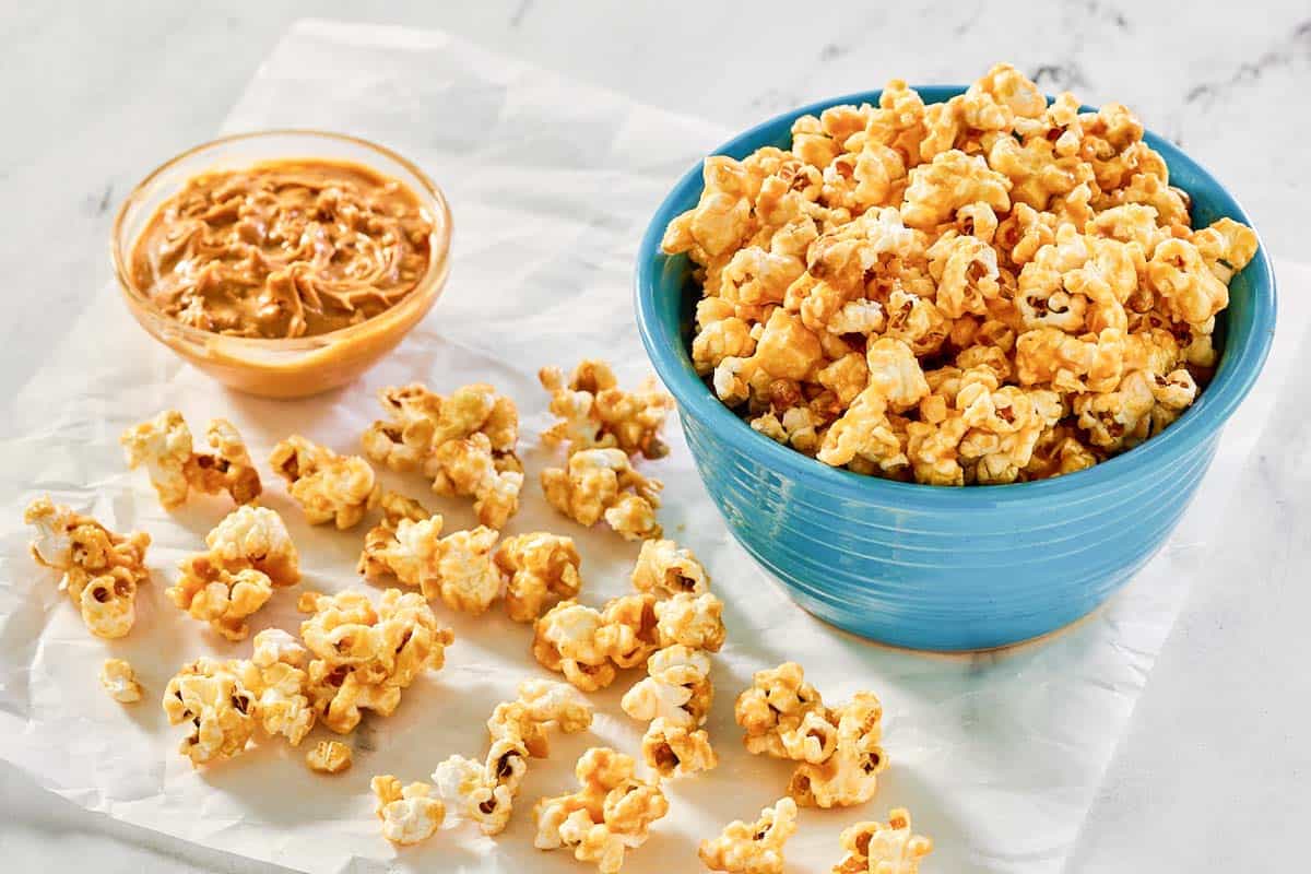 Peanut butter popcorn and a small bowl of peanut butter.
