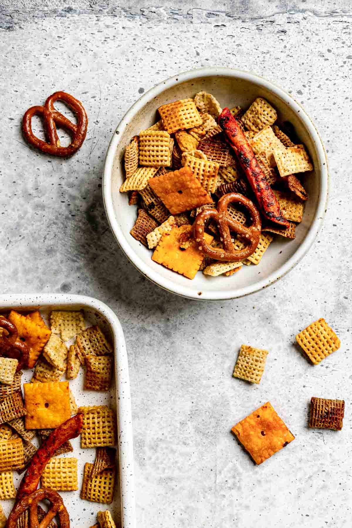 Homemade spicy Chex mix in a bowl and on a baking sheet.