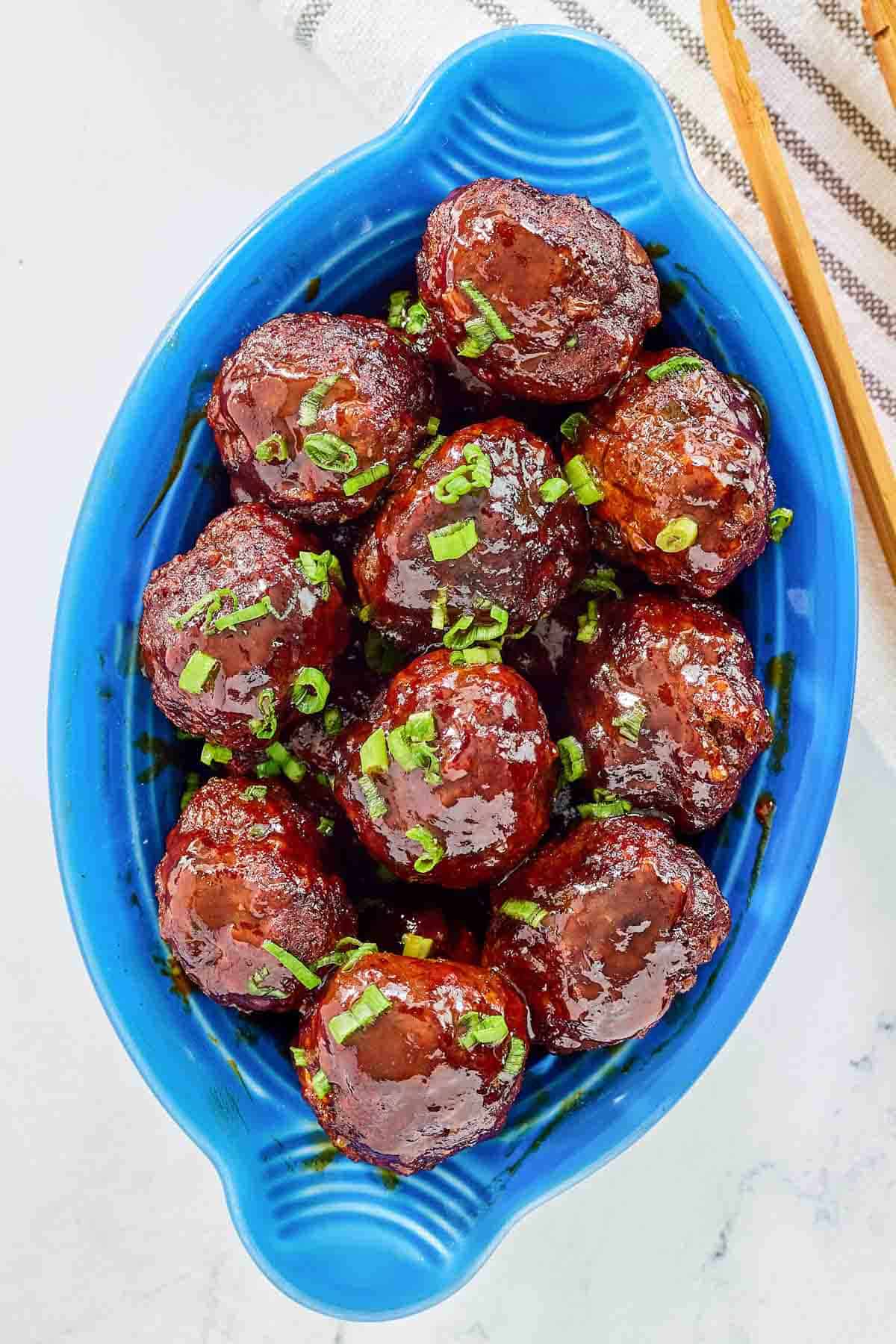 Homemade BBQ meatballs garnished with sliced green onions.