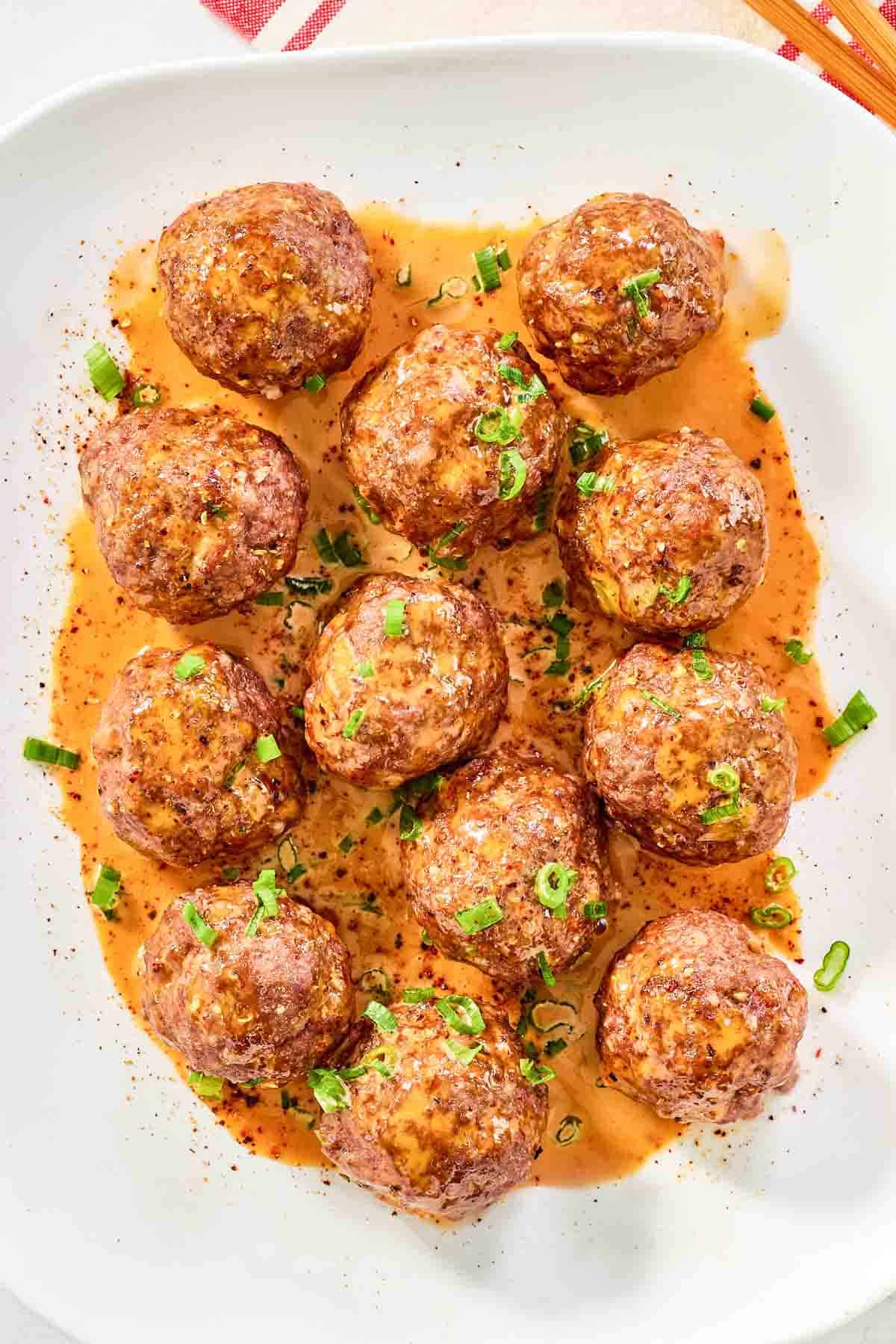 Firecracker meatballs with sauce on a platter.