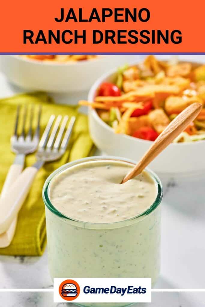 Jalapeno ranch dressing in a jar and a salad behind it.